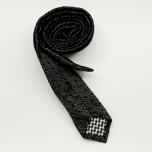 Black patterned tie on a light gray background