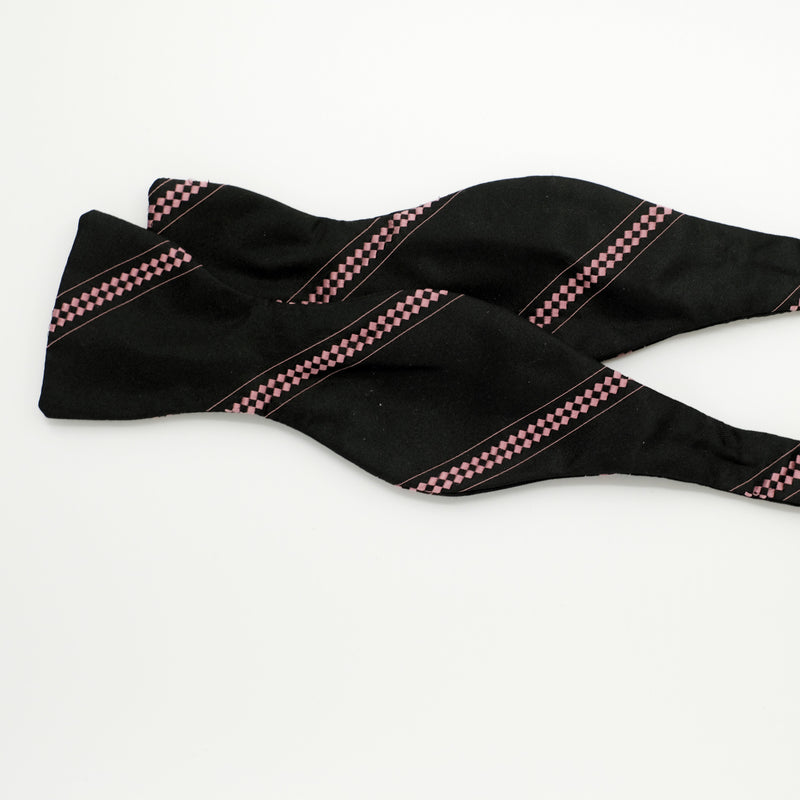 Black bow tie with pink patterns on a white background